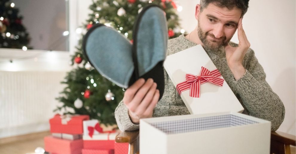 man holding slippers gift he doesnt want